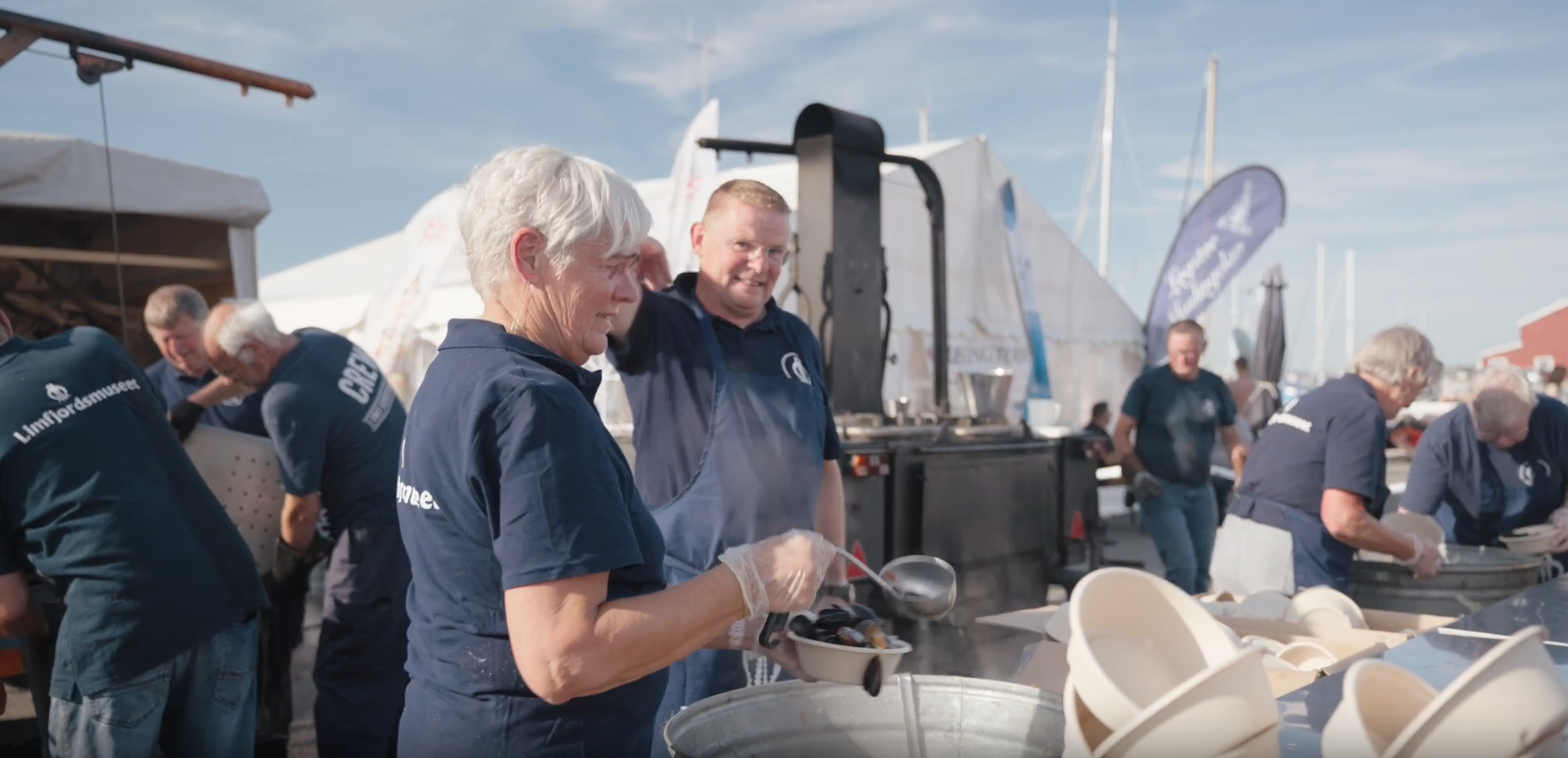 Frivillige serverer mad ved havnen til et lokalt arrangement